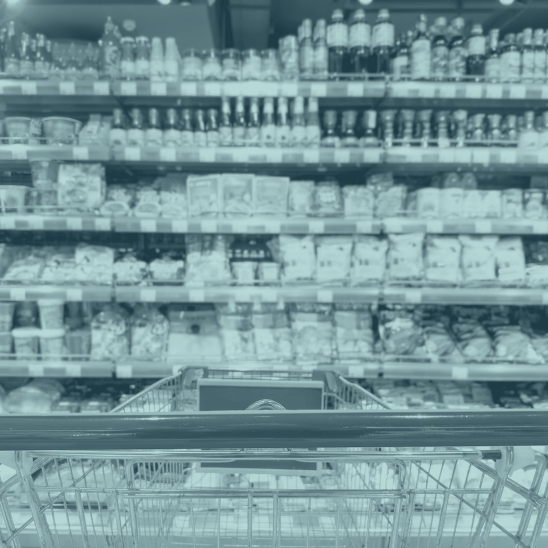 Supermarket shelves seen from behind a shopping trolley