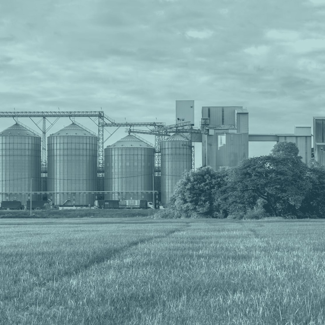 Grain silos beside a green field